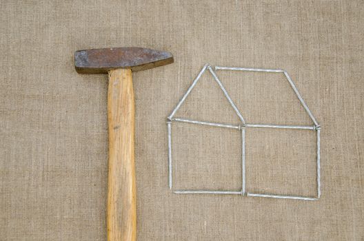 work hammer and outbuilding shape of metallic nail on linen texture background