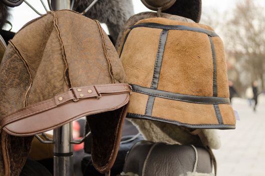 male brown decorated winter hats on rack outdoor
