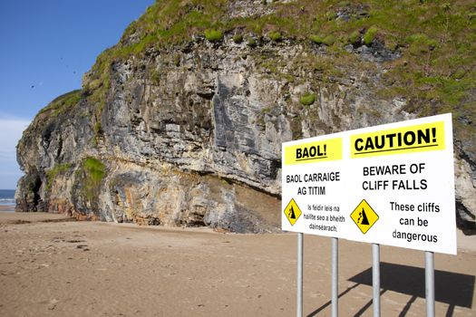 beware of land falls warning sign beside the cliffs in Ballybunion county Kerry Ireland in English and Gaelic