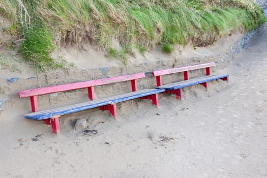 bench covered in sand from the winter storms in Ireland
