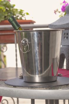 Bottle of wine in a bucket, with sunset sky on the back