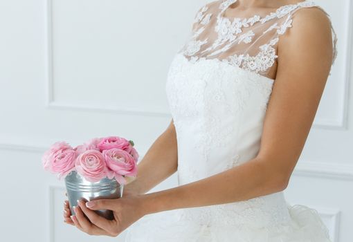 Wedding. Attractive bride holding pot with beautiful roses