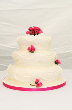 Wedding cake at reception with pink details.