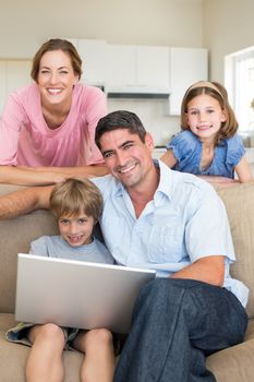 Portrait of family using laptop together in living room