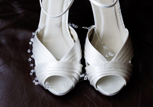 Closeup detail of brides shoes and necklace on wedding day