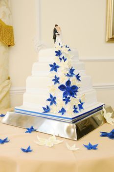 Blue and white wedding cake closeup with bride and groom on top