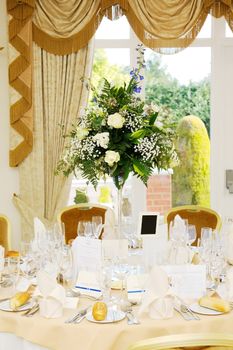 Arrangement of flowers with white roses decorate wedding reception
