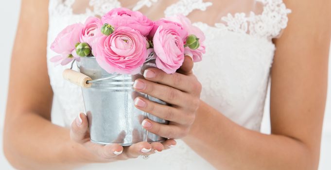 Wedding. Attractive bride holding pot with beautiful roses