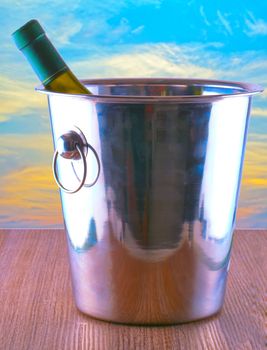 Bottle of wine in a bucket, with sunset sky on the back