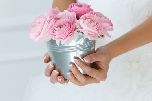 Wedding. Attractive bride holding pot with beautiful roses