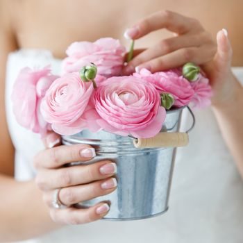 Wedding. Attractive bride holding pot with beautiful roses