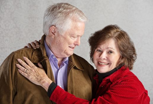 Grinning senior husband looking at his smiling wife