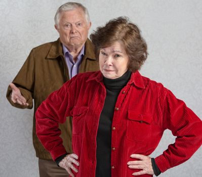 Suspicious senior woman in front of confused man