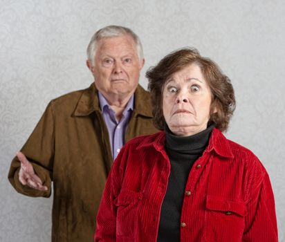 Stiff older woman in front of confused man