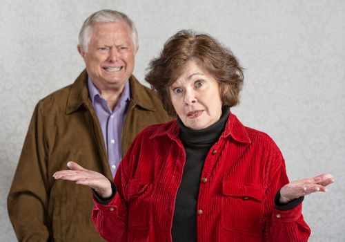 Frustrated woman with hands up and angry man