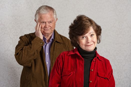 Senior male blushing while happy woman is smiling