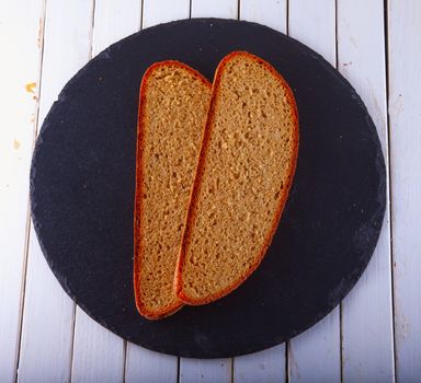 Two slices of bread over black stone