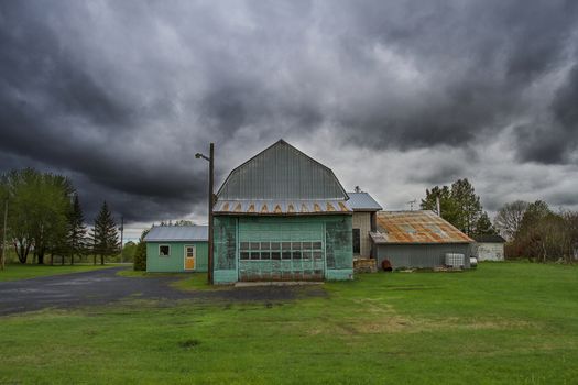 Green barn under dark storm clouds