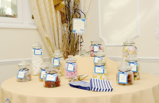 Decorated table at wedding reception with candy buffet