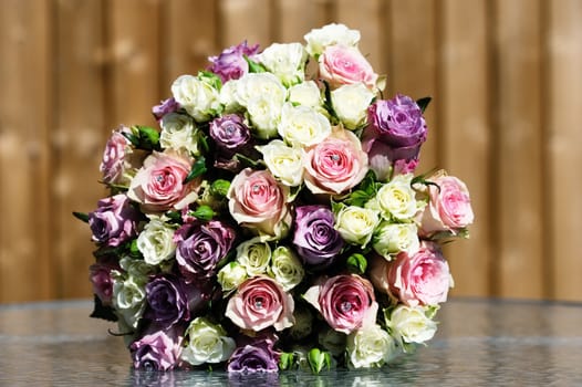 Closeup of brides flowers on wedding day are pink and purple roses