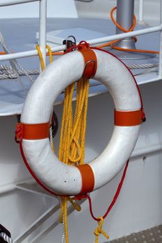 Life preserver and rope hanging from the railing of a boat