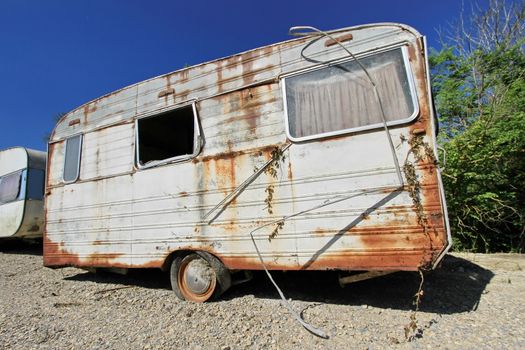 Old decayed and abandoned caravan in nature