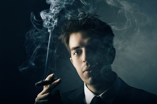 Young handsome stylish man smoking cigar, Fashion portrait