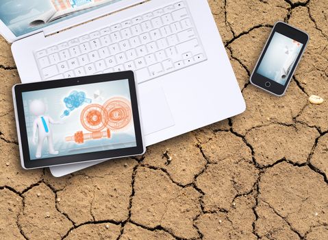 Laptop, tablet pc and smart phone on cracked ground surface. Computer technology concept