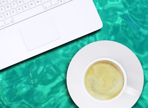 Laptop and coffee cup on water surface. Computer technology concept