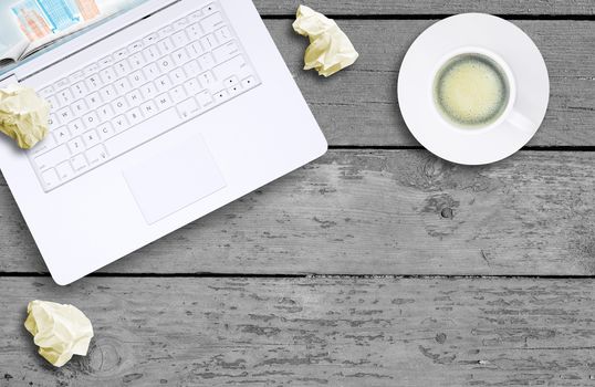 Laptop and coffee cup on old wooden boards. Computer technology concept