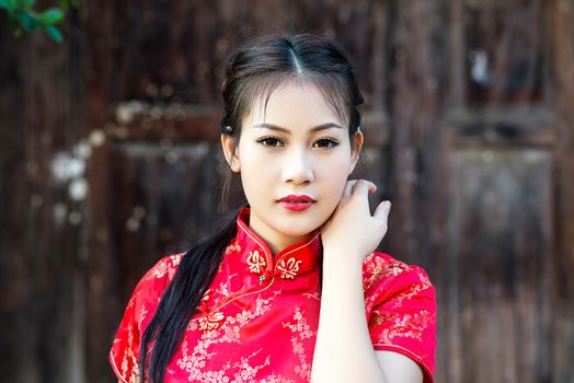 Chinese girl in traditional Chinese cheongsam blessing