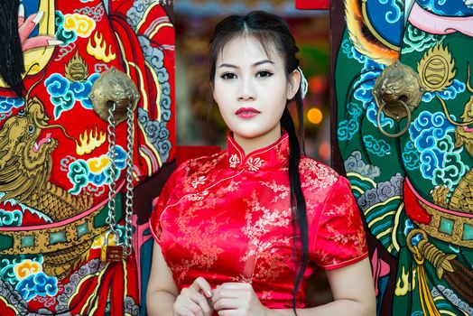 Chinese girl in traditional Chinese cheongsam blessing