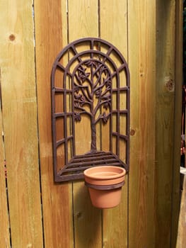 Empty decorative clay flower pot on a wooden wall