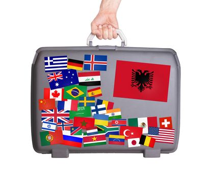 Used plastic suitcase with lots of small stickers, large sticker of Albania