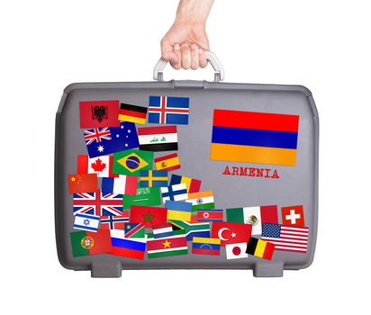 Used plastic suitcase with lots of small stickers, large sticker of Armenia