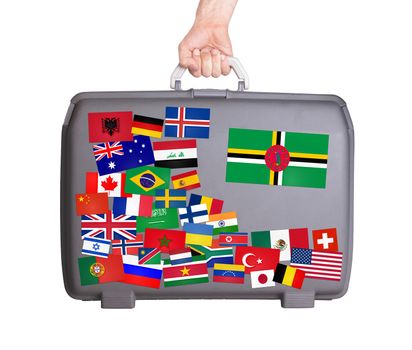 Used plastic suitcase with lots of small stickers, large sticker of Dominica