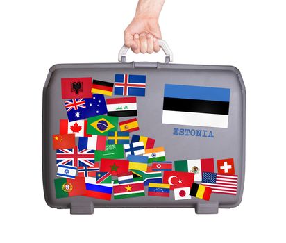 Used plastic suitcase with lots of small stickers, large sticker of Estonia