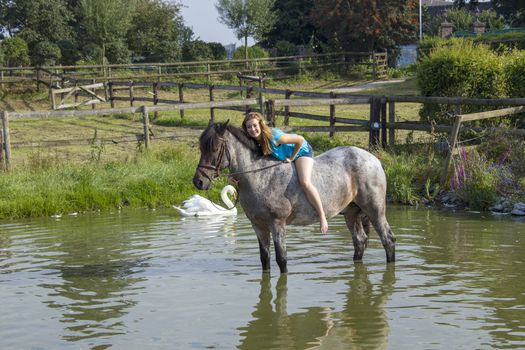 young girl riding a horse outdoors