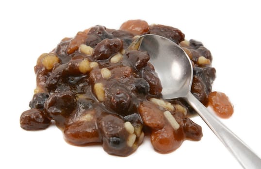 Closeup of traditional mincemeat mixture of dried fruit, candied peel and suet, with a metal teaspoon, isolated on a white background