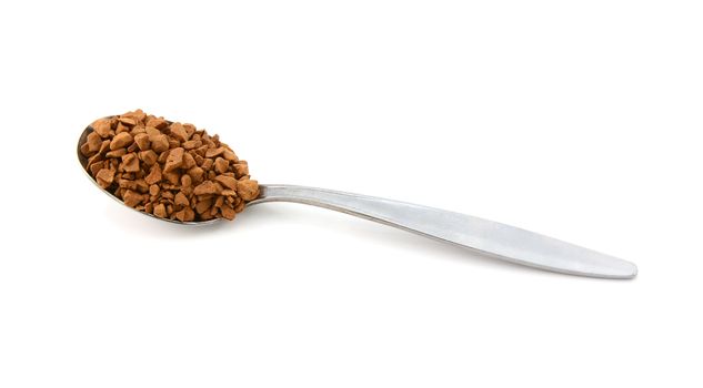 Metal teaspoon measure of instant coffee granules, isolated on a white background