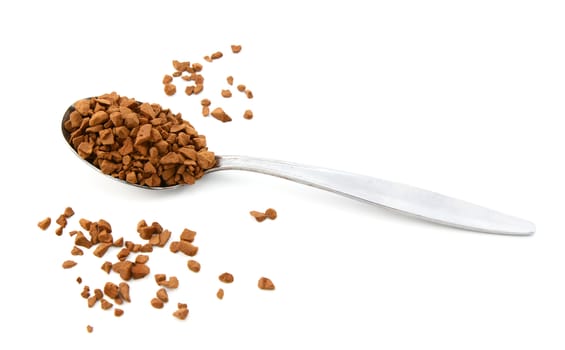 Teaspoon of instant coffee with some granules spilled around the spoon, isolated on a white background