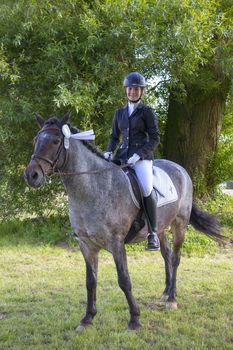 young girl riding a horse outdoors