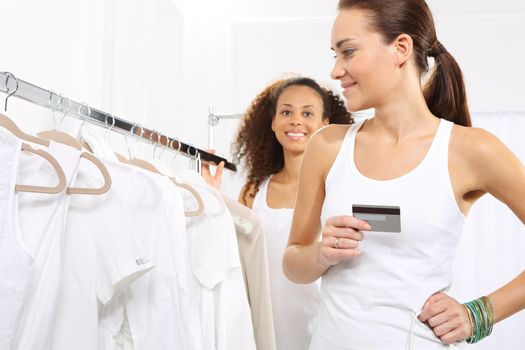 Woman in clothing store pay for purchases by credit card.