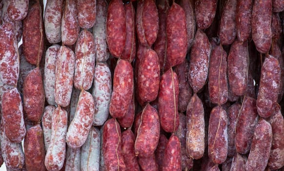 Close up of delicious Italian salami hanging on the rope