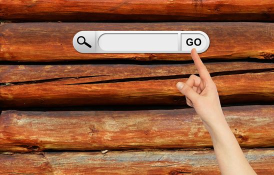 Human hand indicates the search bar in browser. Old wooden wall on background