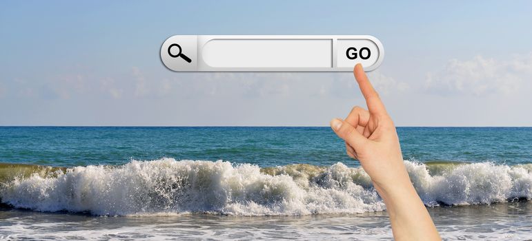 Human hand indicates the search bar in browser. Waves breaking on stony beach as backdrop