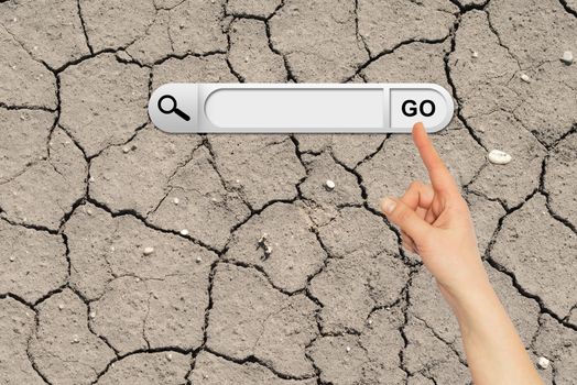 Human hand indicates the search bar in browser. Cracked ground surface on background