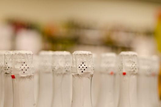 close up of champagne bottleneck with glossy white paper