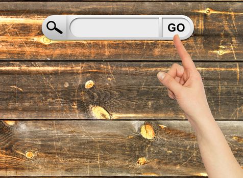 Human hand indicates the search bar in browser. Aged wooden painted surface on background