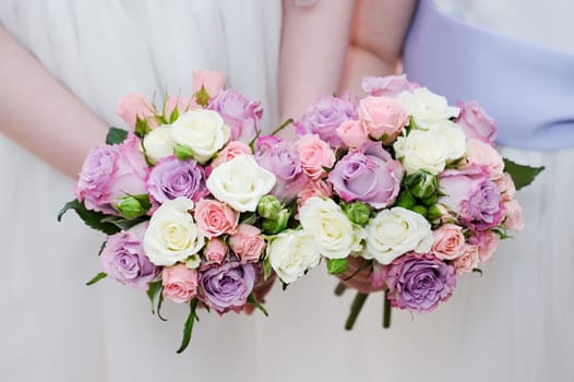 Bridesmaids two bouquet of flowers are pink and purple roses